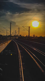 Railroad tracks against sky during sunset