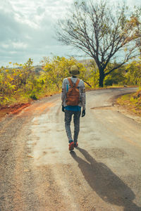 Rear view of man walking on road