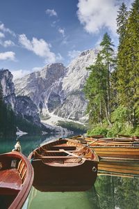 Boats moored on lake against mountains
