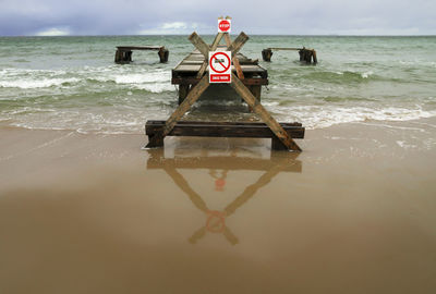 Lifeguard hut in sea against sky