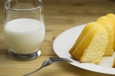 Close-up of lemon cake and milk on table