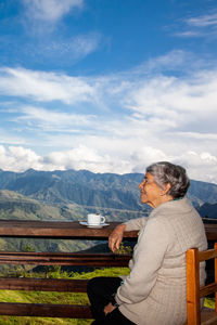 Senior woman tourist looking at the  landscapes of the central ranges in colombia. travel concept