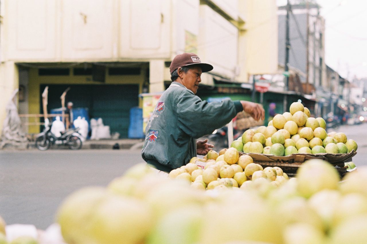 FULL LENGTH OF MAN HAVING FOOD IN MARKET STALL