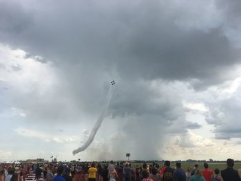 Group of people on airplane against sky