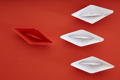 Directly above shot of paper boats on red background