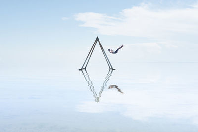 Self portrait on swing set in reflection on salton sea californi