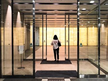 Rear view of woman standing in illuminated building