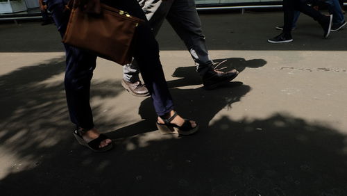 Low section of man standing on road