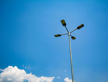 Low angle view of street light against blue sky