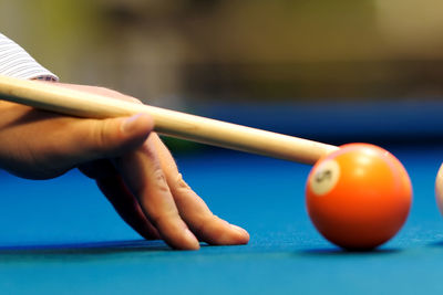 Cropped hand of man playing pool