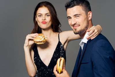 Portrait of young couple holding hands over black background