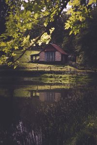 House by lake against trees