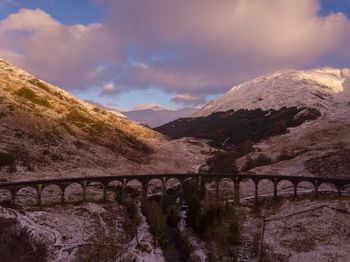 Bridge over mountains against sky