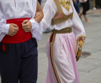 Midsection of friends standing on street