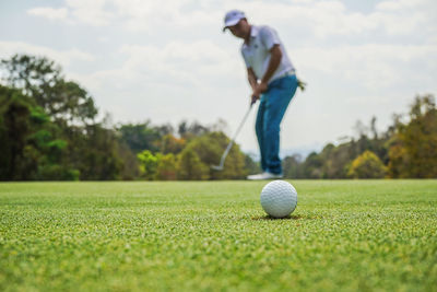 Man holding ball while standing on grass