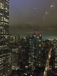 Illuminated buildings in city against sky at night