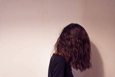 Rear view of woman standing against wall