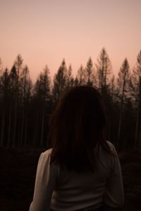 Portrait of young woman standing against sky during sunset