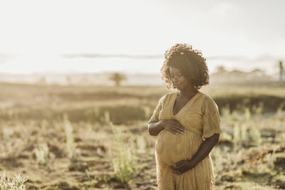 Portrait of pregnant mother in third trimester at beach at sunset