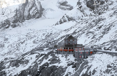 Snow covered buildings against mountain