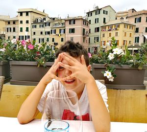 Portrait of teenage girl sitting on table against building