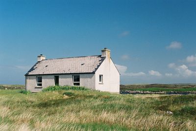 House on field against clear sky