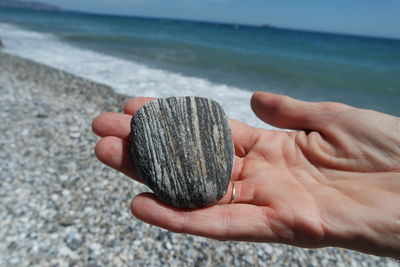 Close-up of hand holding sand on beach