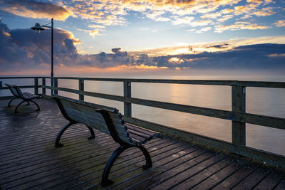 Pier over sea against sky during sunset