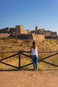 Rear view of woman against clear blue sky