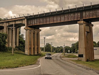 Cars on road against cloudy sky