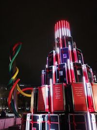 Low angle view of illuminated ferris wheel against sky at night