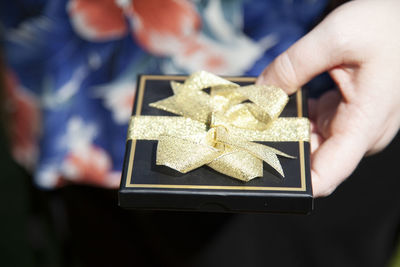Midsection of woman opening gift