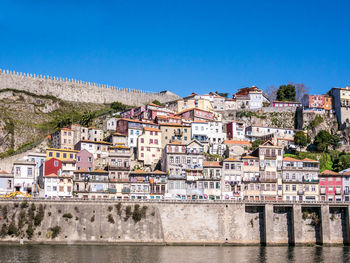 Buildings in city against blue sky