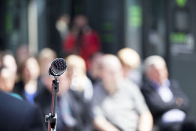 Close-up of microphone against crowd