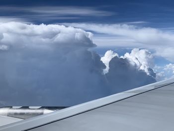 Aerial view of cloudscape and airplane flying in sky