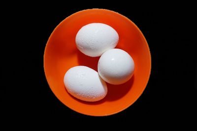 High angle view of orange eggs against black background
