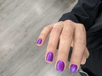 Close-up of woman hand on purple wall