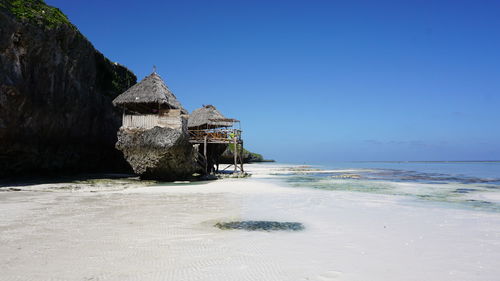 Built structure on beach against clear blue sky