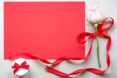 Close-up of rose and gift on table