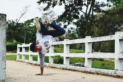 Man practicing stunt on road in park