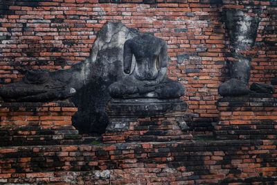 Old statue against brick wall