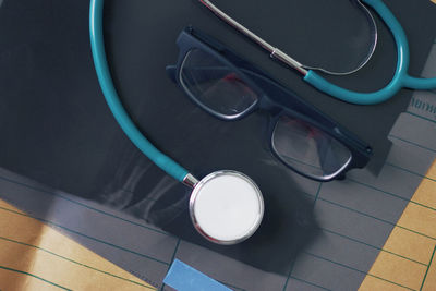 High angle view of stethoscope and eyeglasses