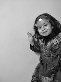 Portrait of smiling girl standing against white background