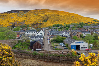 Scenic view of townscape by mountains against sky