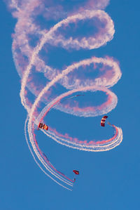 Low angle view of airplane flying against blue sky