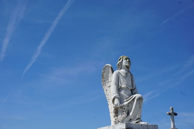 Low angle view of statue against blue sky