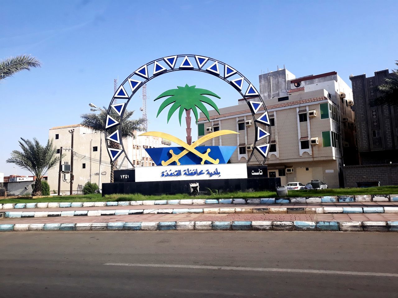 architecture, built structure, building exterior, tree, city, nature, sky, day, text, building, communication, no people, plant, palm tree, tropical climate, western script, sunlight, outdoors, street, clear sky