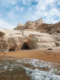 Rock formations by sea against sky