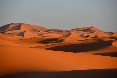 Scenic view of desert against clear sky during sunset