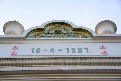 Low angle view of text on building against clear sky